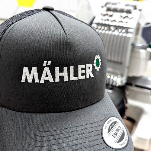 zu sehen ist eine schwarze cap mit einem weißen Logo das daraufgestickt wurde