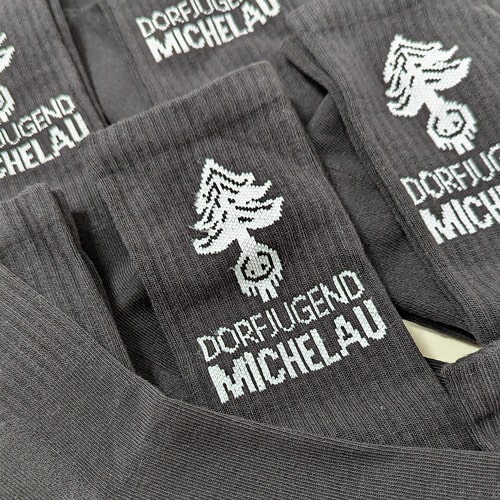 Socken besticken lassen hat sich auch die Dorfjugend Michelau. Zu sehen sind sie hier in schwarz mit weißen Stick ihres Schriftzuges