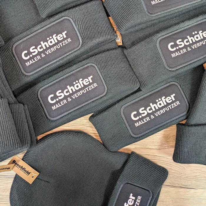 Bedruckte schwarze Mützen mit dem Logo C. Schäfer von Lamasuli Schweinfurt