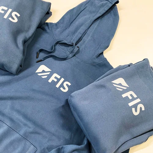 Mitarbeiterkleidung für FIS Informationssysteme und Consulting GmbH – Projekt mit Lamasuli Schweinfurt 1 Nahaufnahme von blauen Hoodies mit DTF-Druck der Firma FIS, hergestellt von Lamasuli