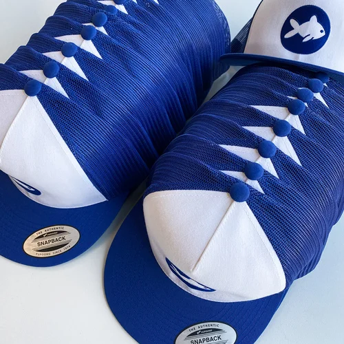 Merchandise personalisieren für Fishing Elements in Schweinfurt mit Lamasuli 1 Nahaufnahme von blauen Caps mit Stickerei für Fishing Elements von Lamasuli
