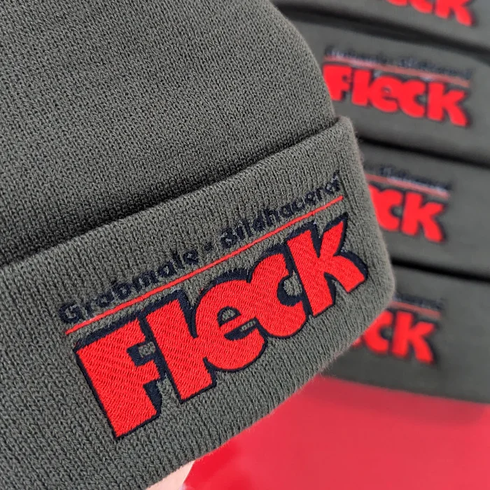 Sichtbarkeit für regionale Handwerksbetriebe mit Grabmale Bildhauerei Fleck 1 Nahaufnahme von grauen Mützen mit Stickerei für Grabmale Bildhauerei Fleck von Lamasuli
