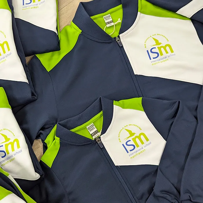 Sportjacken in Dunkelblau und Grün mit ISM-Logo der International School Mainfranken in Schweinfurt