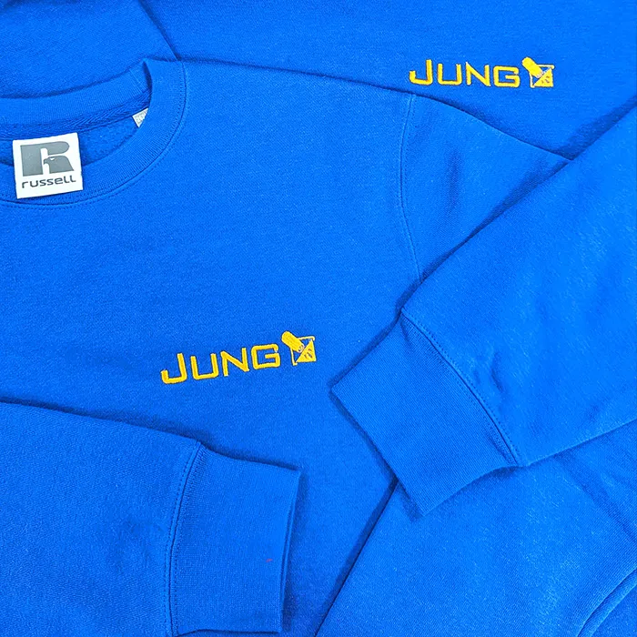 Blaue Sweatshirts mit besticktem JUNG-Logo für den Arbeitsalltag in Unterfranken
