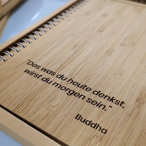 zu sehen ist ein Notizbuch mit einem Einband aus Bambus und veredelt mit einer Lasergravur und einer Weisheit von Buddha