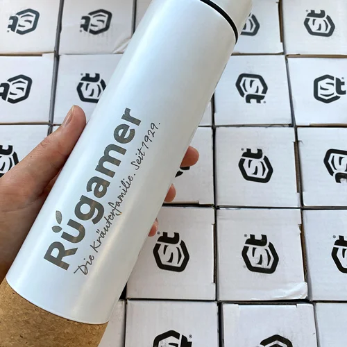 Personalisierte Mitarbeiterausstattung für Georg Rügamer GmbH in Schwebheim mit Lamasuli 3 Eine weiße Thermoflasche mit dem Logo Rügamer von Lamasuli
