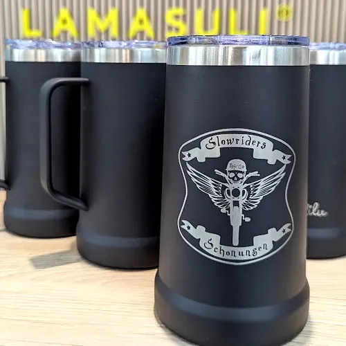 Gravur auf dem vordersten schwarzen Thermobecher mit einem Motorrad-Totenkopf-Logo, umgeben von den Schriftzügen "Slowriders" und "Schonungen".